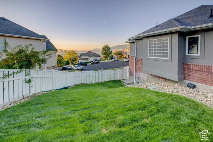 Lush green lawn with a white privacy fence