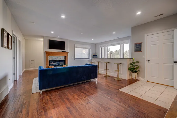 Hardwood flooring, recessed lighting, and a built-in fireplace with a wood mantel