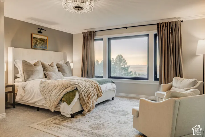 Expansive window with mountain scenery, crown molding, a crystal chandelier, recessed lighting, and carpet flooring