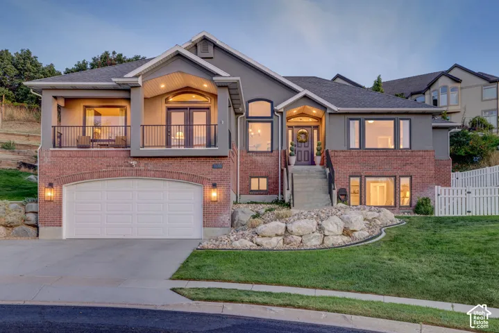 Stucco and brick exterior with a prominent arched two-car garage