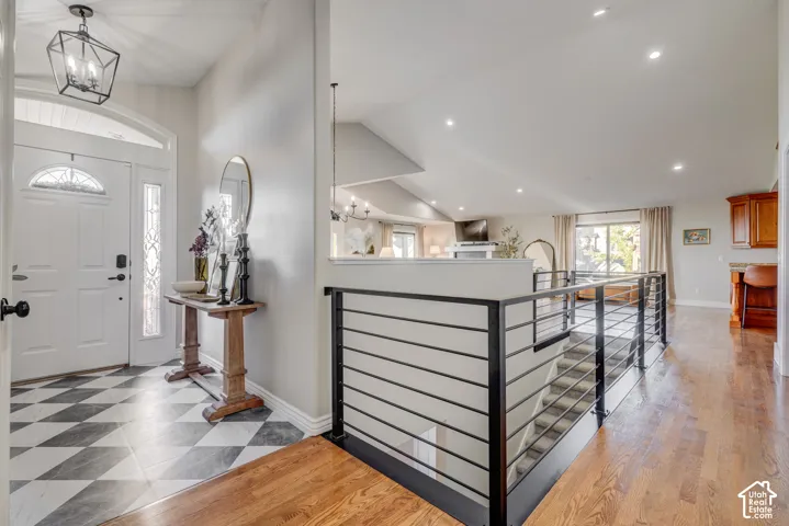 Entryway featuring checkerboard tile flooring, a decorative glass front door, and a modern geometric pendant light