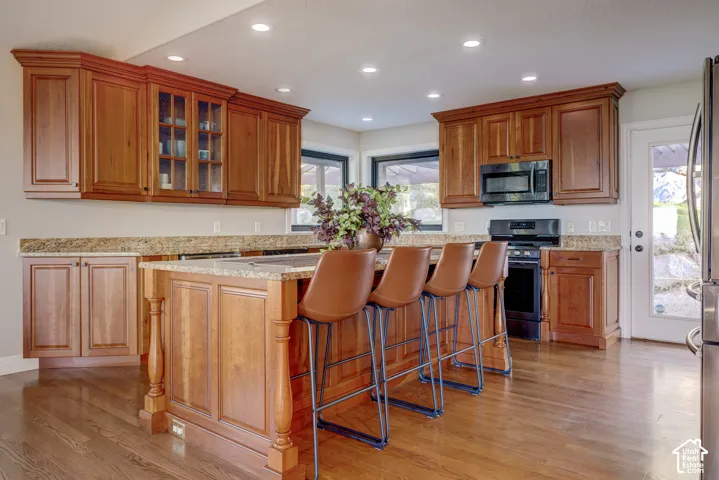 Kitchen featuring wood-finish flooring, recessed lighting, and a center island with counter seating