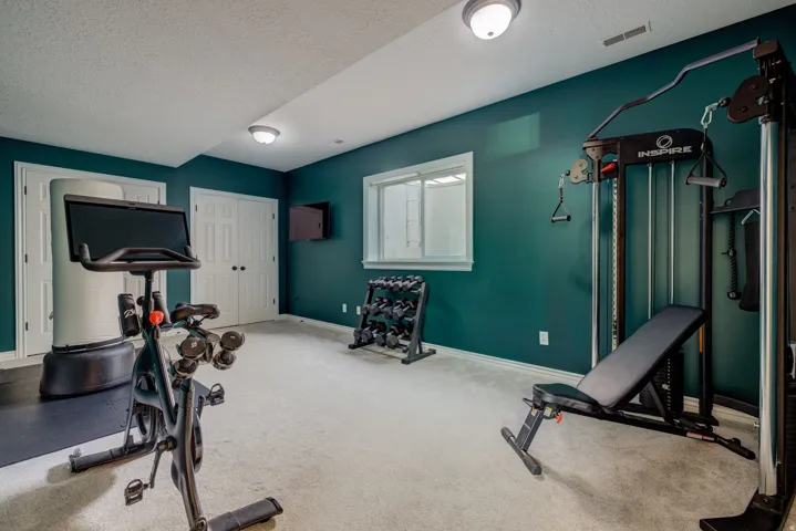 Carpeted room with deep teal accent walls, white trim, and a white ceiling