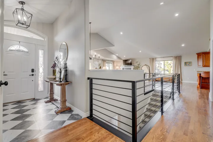 Entryway featuring checkerboard tile flooring, a decorative glass front door, and a modern geometric pendant light