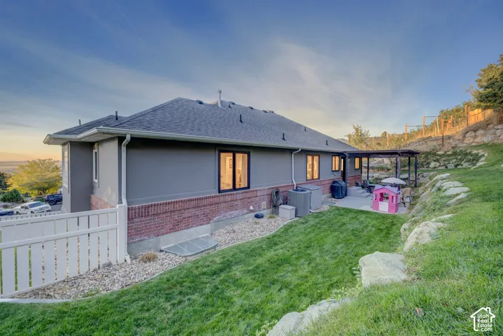 Expansive backyard featuring a manicured lawn, a concrete patio, and a covered pergola