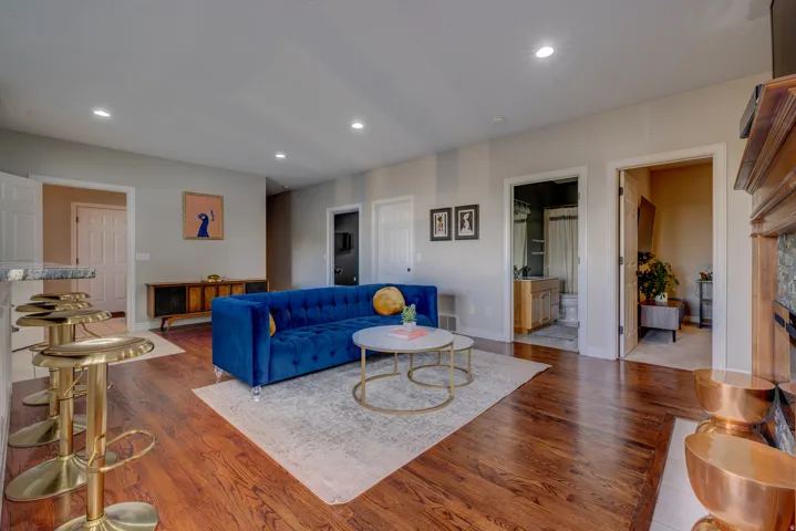 Hardwood-finish flooring, recessed lighting, neutral wall tones, and a wood mantel with tile surround