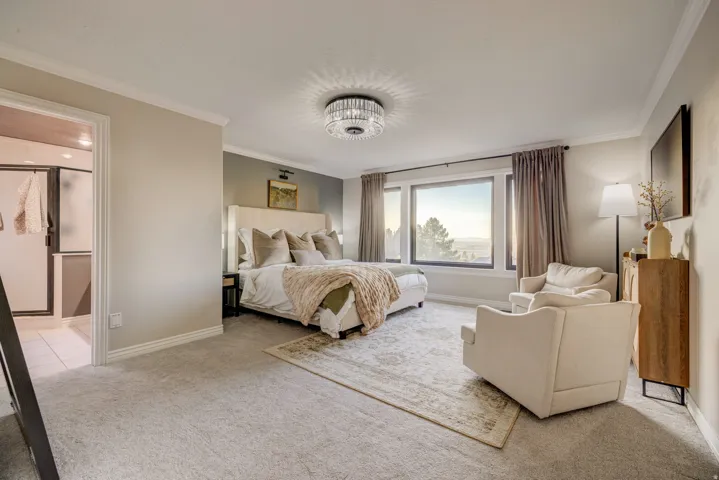 Expansive room featuring wall-to-wall carpeting and crown molding