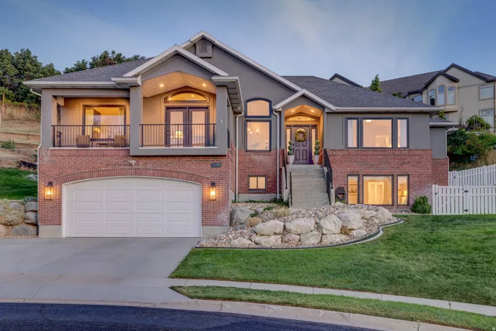 Stucco and brick exterior with a prominent arched two-car garage
