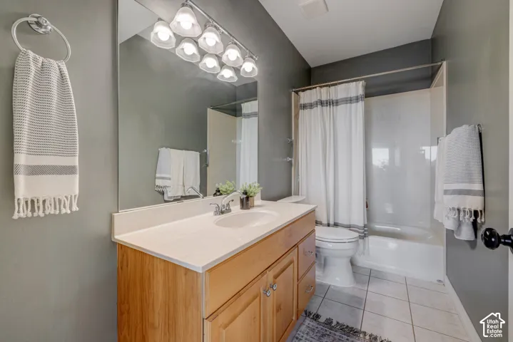 Single vanity with light wood-finish cabinetry, white countertop, and integrated sink