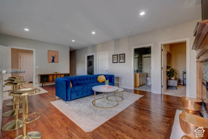 Hardwood-finish flooring, recessed lighting, neutral wall tones, and a wood mantel with tile surround