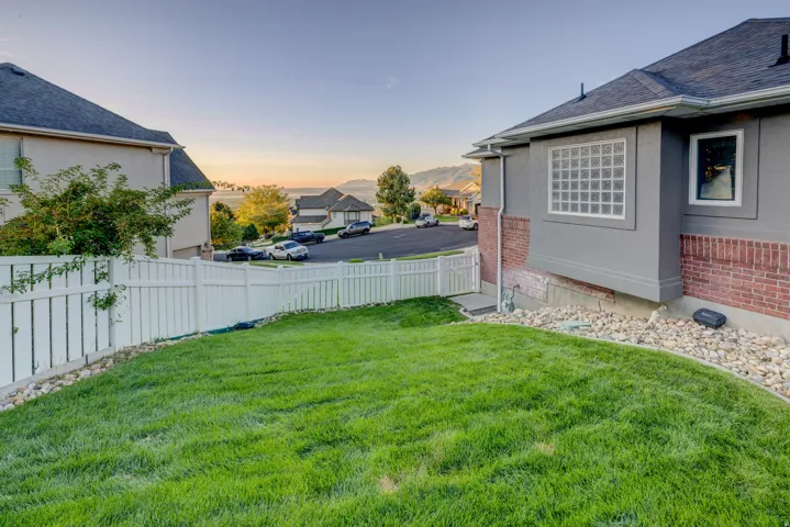 Lush green lawn with a white privacy fence