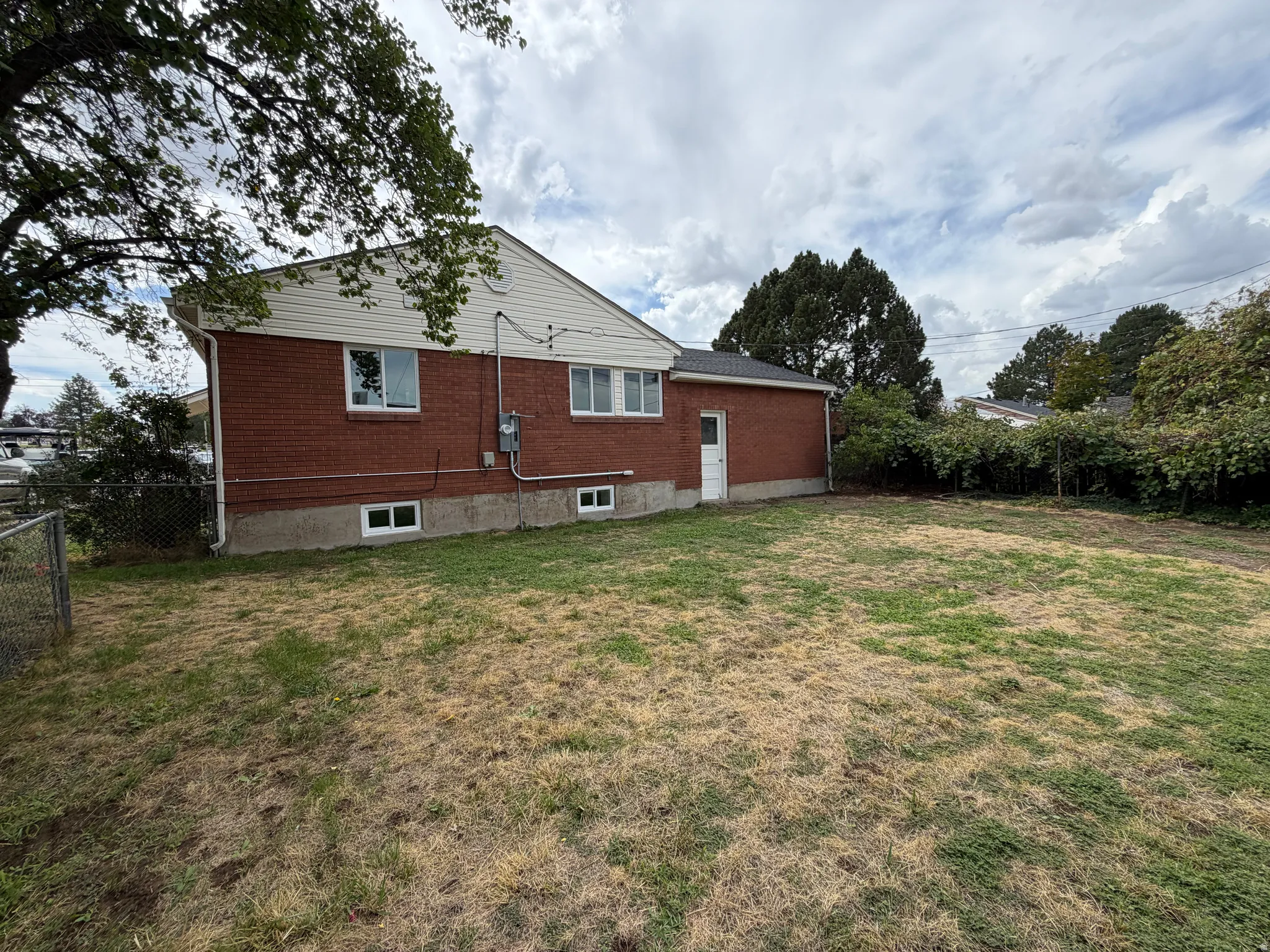 Brick exterior with white trim, multiple windows, and a side entrance