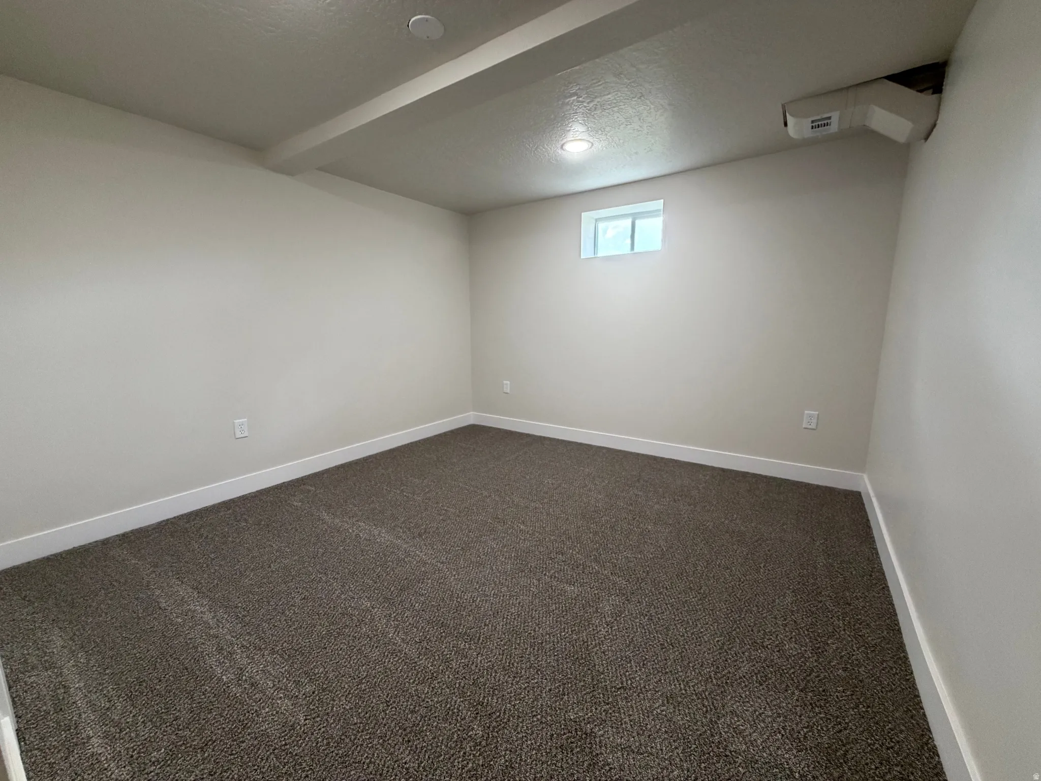 Neutral wall paint, textured carpet flooring, white trim, recessed lighting, and a single-pane window