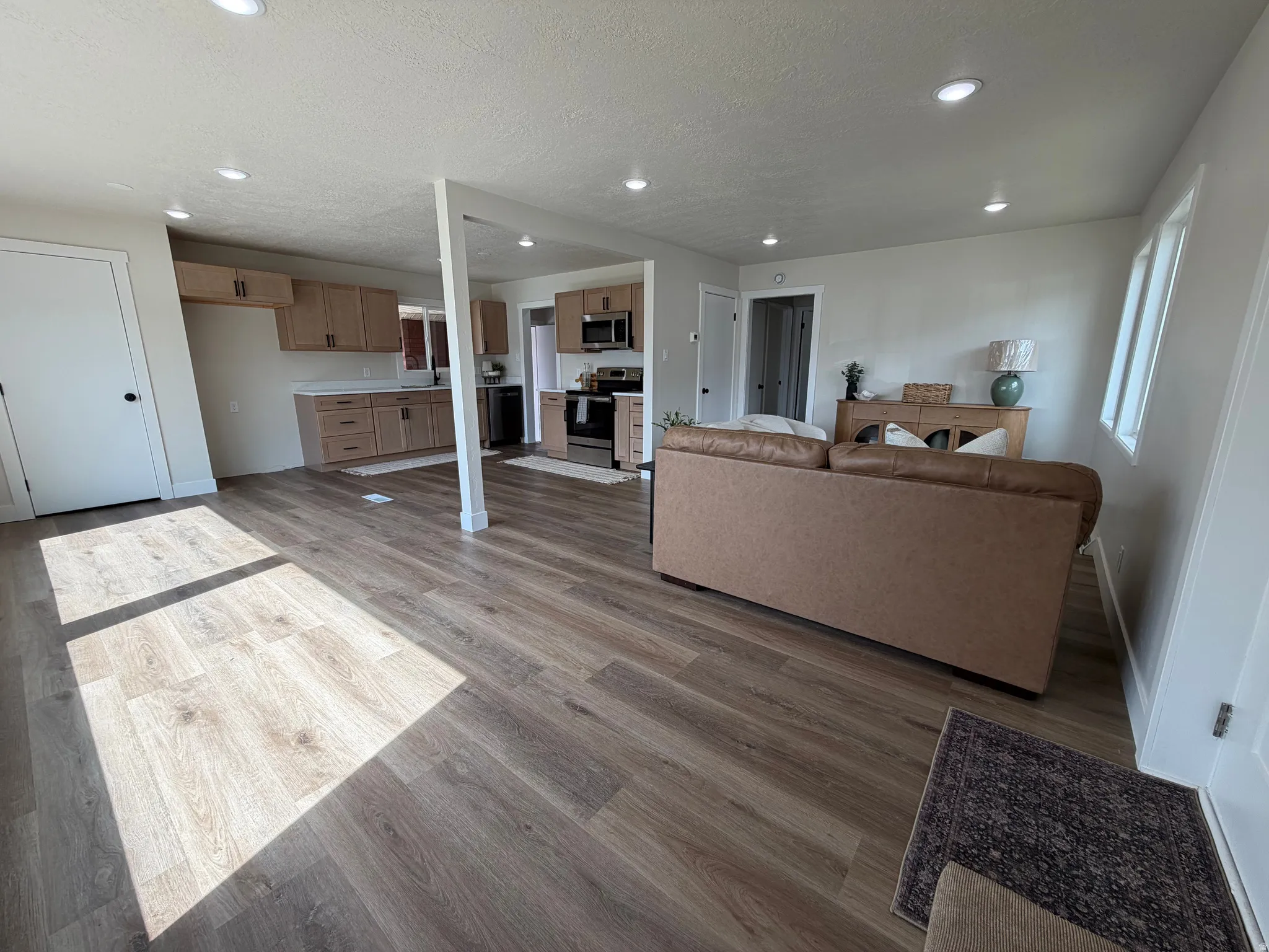 Open-concept living space with wood-finish flooring, recessed lighting, and light-toned walls