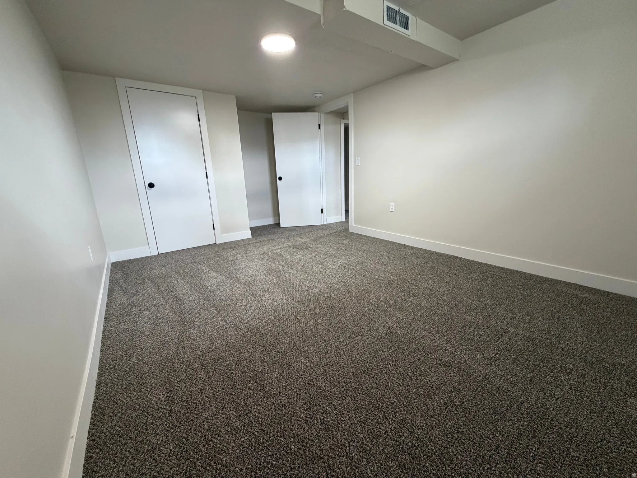 Neutral tone walls, recessed lighting, and soft pile carpeting