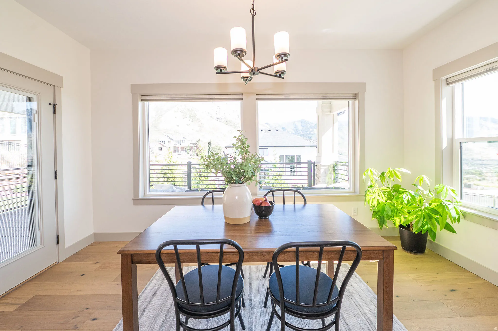 Bright Dining Room Featuring Multiple Windows and a Glass-Paneled Door Leading onto The Deck