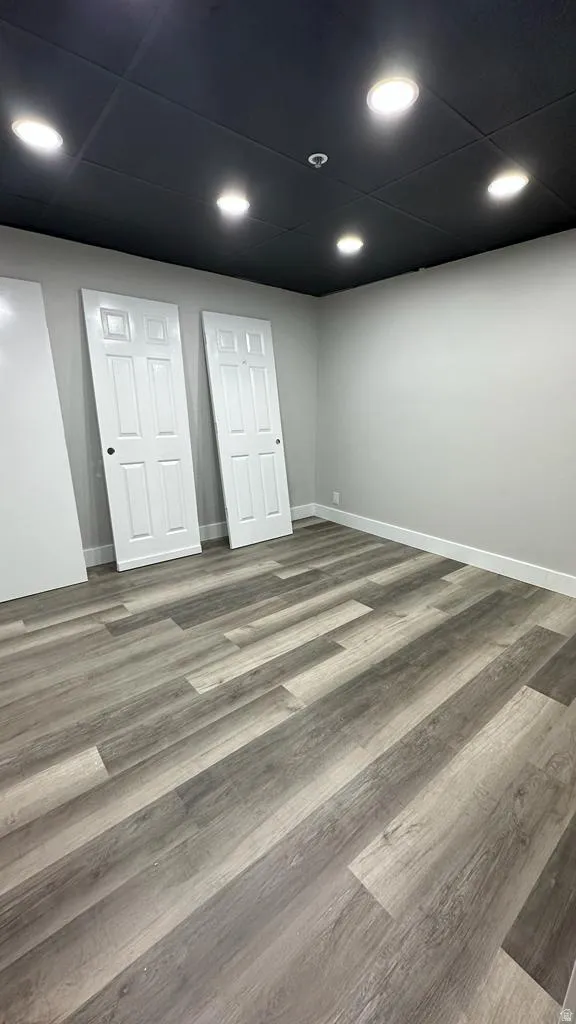 Wood-finish flooring, recessed lighting, and a dark ceiling