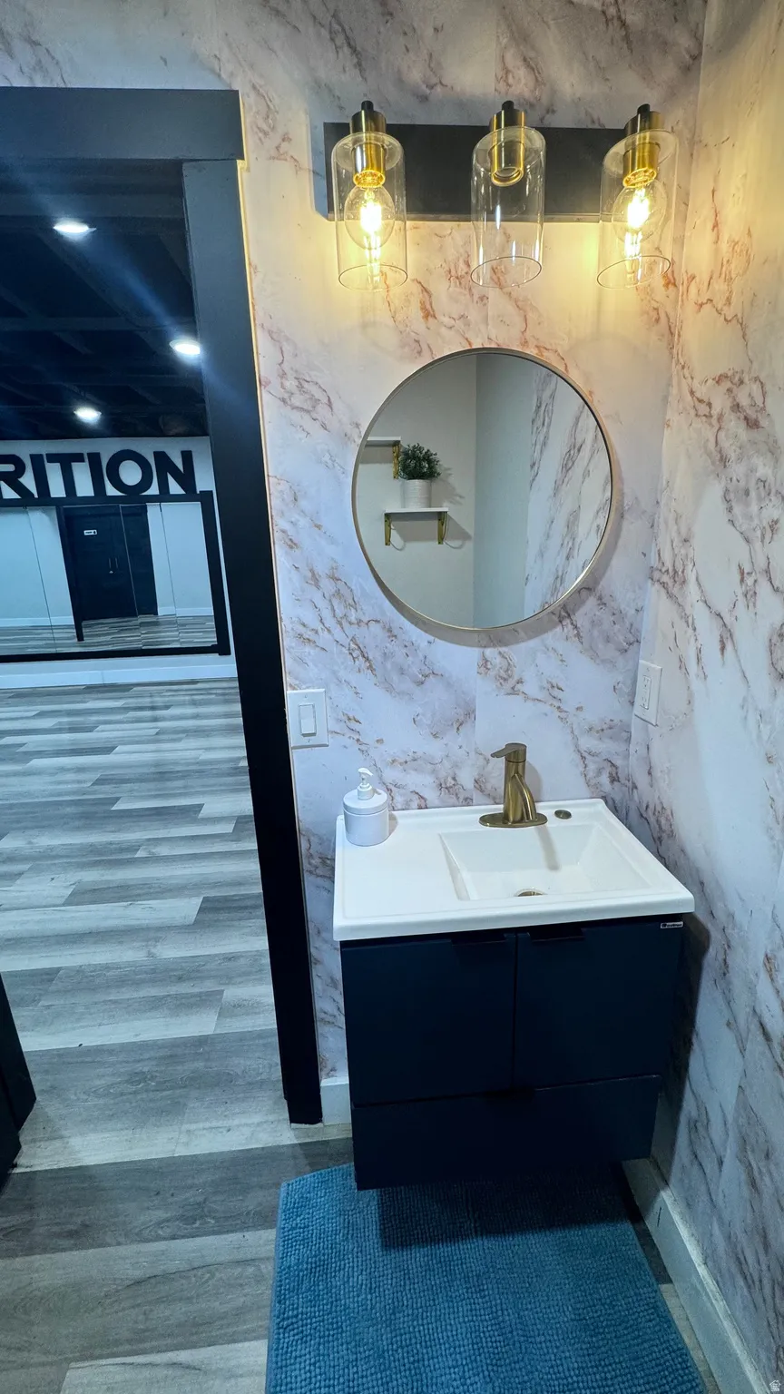 Floating vanity with a white rectangular sink and gold-finish faucet