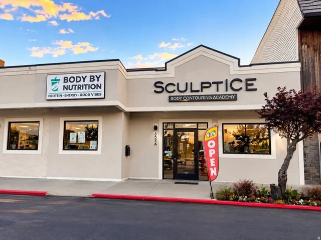 Commercial storefront with prominent signage, multiple display windows, and a landscaped entrance