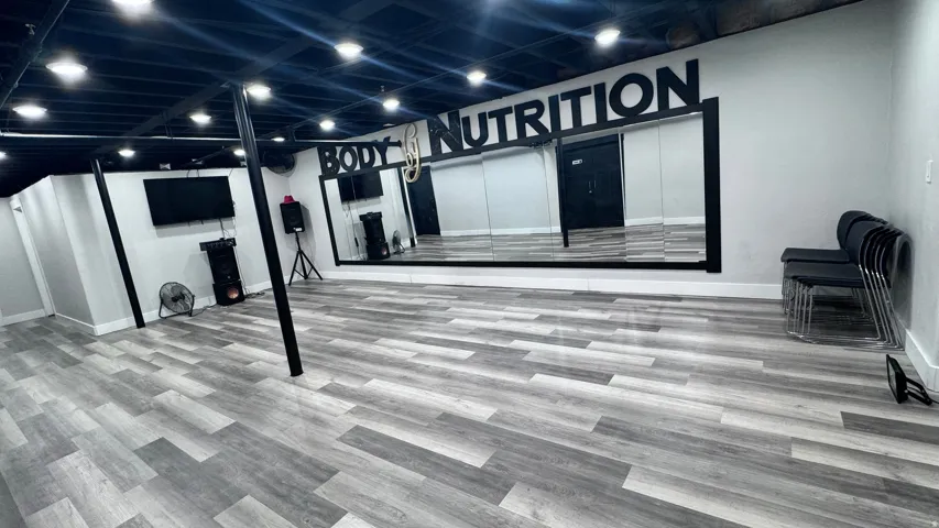 Expansive room featuring wood-finish flooring, a wall-mounted mirror, and recessed lighting