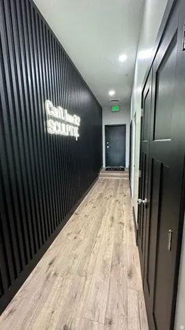Wood-finish flooring with a matte black paneled accent wall