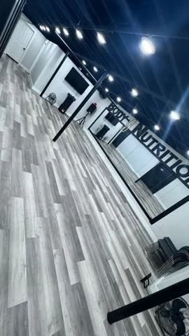 Light wood-finish flooring, recessed ceiling lighting, and a full-wall mirror