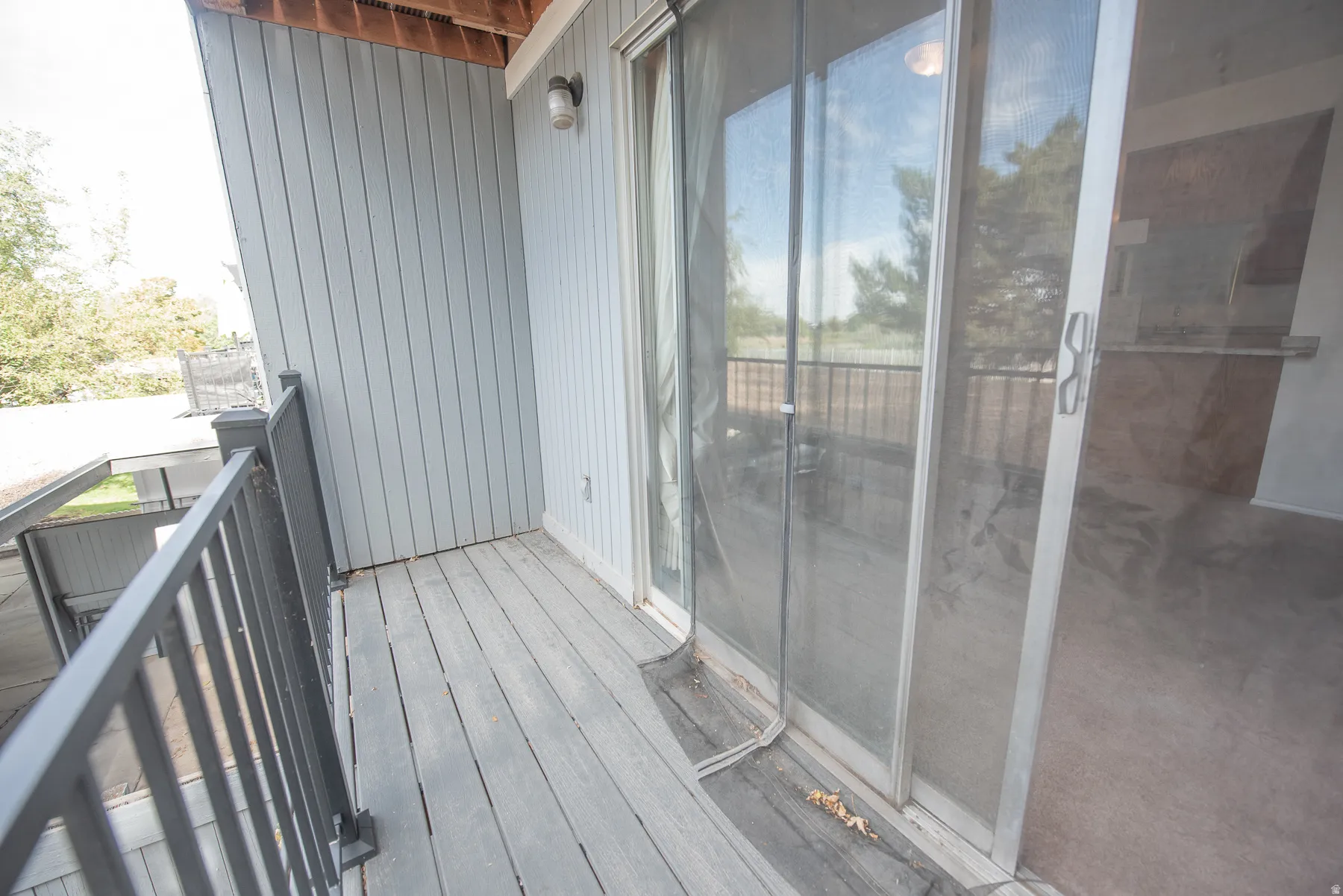 Private balcony featuring wood-finish decking and metal railings