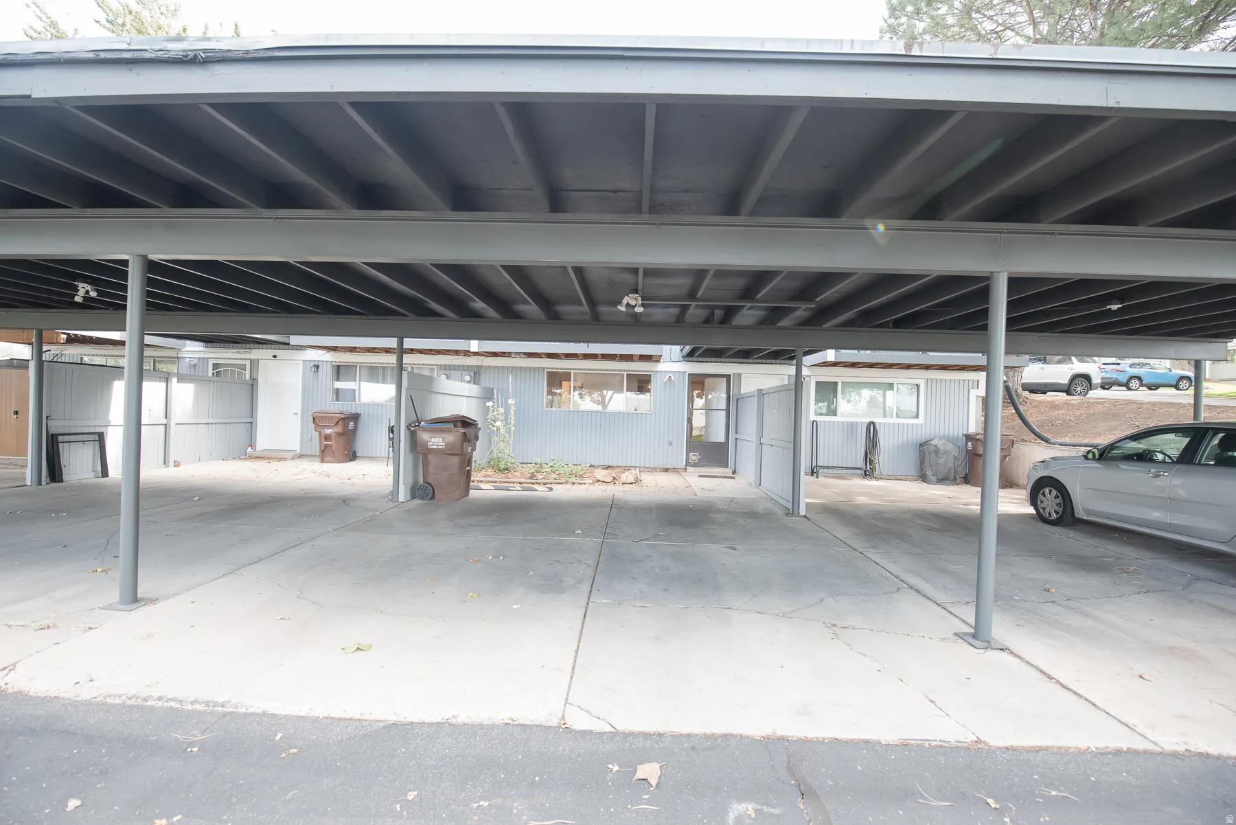 Carport structure with multiple parking spaces and a concrete surface
