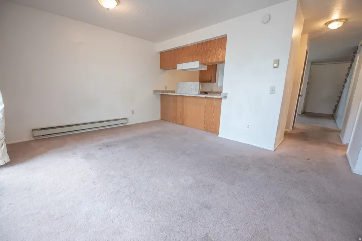 Carpeted living area with baseboard heating