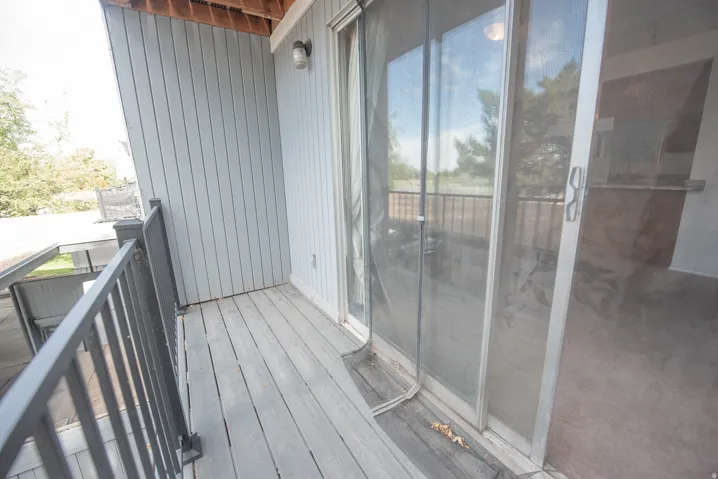 Private balcony featuring wood-finish decking and metal railings