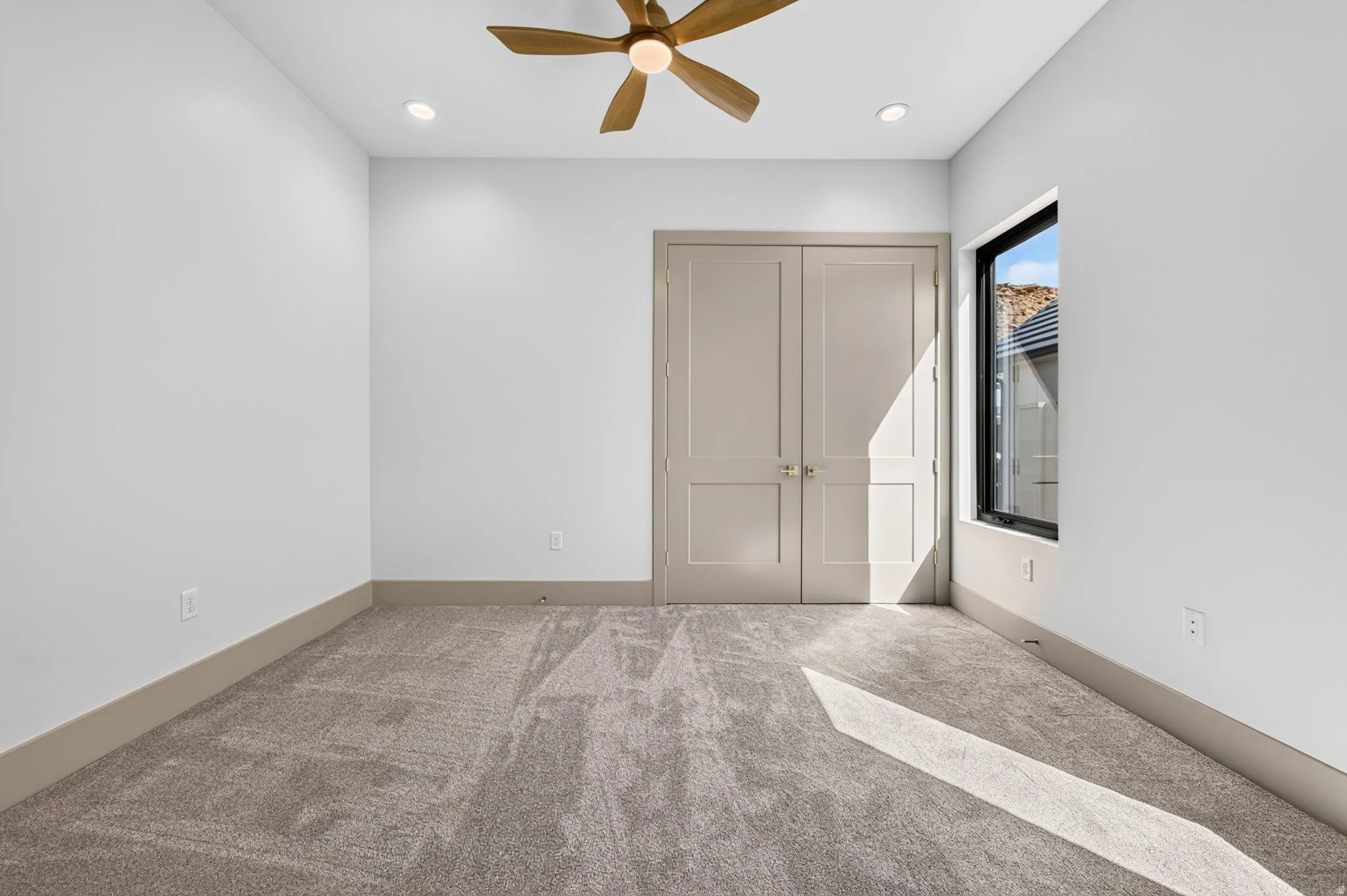 Room featuring neutral carpeting, a ceiling fan, recessed lighting, and a double-door entry
