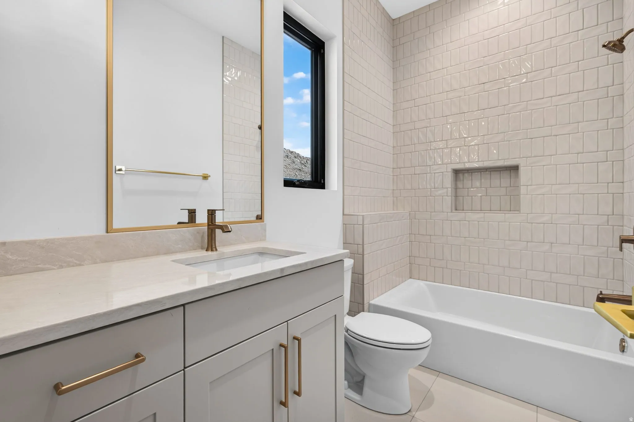 Light-toned vanity with an integrated sink and bronze-finish faucet