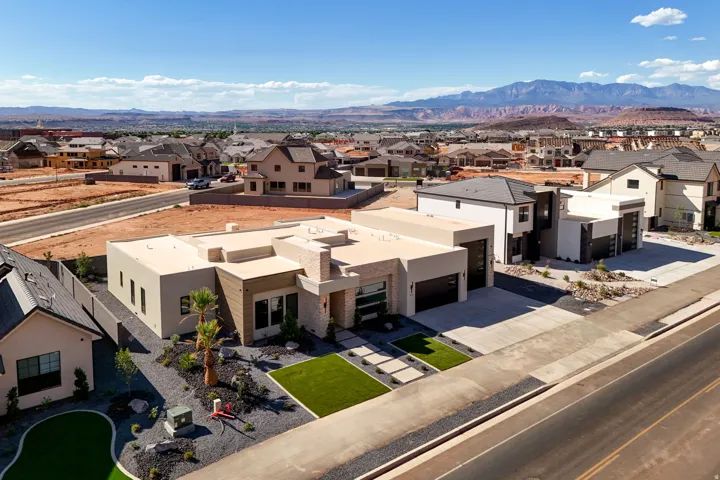 Modern exterior with stone accents, a flat roof, and a two-car garage