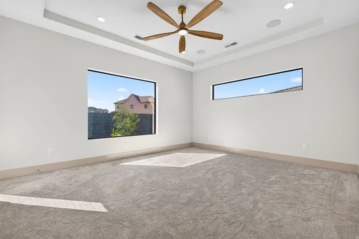 Tray ceiling with recessed lighting and a wood-finish ceiling fan