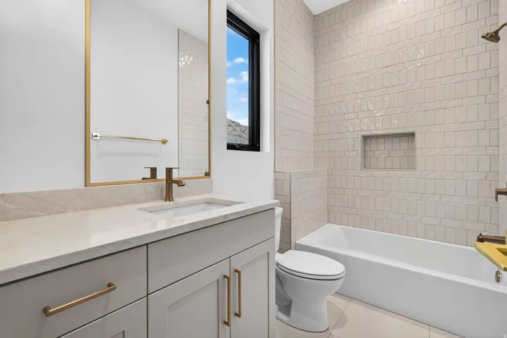 Light-toned vanity with an integrated sink and bronze-finish faucet