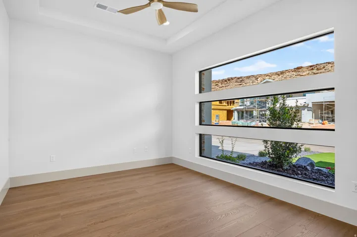 Wood-finish flooring with crisp white walls and a tray ceiling
