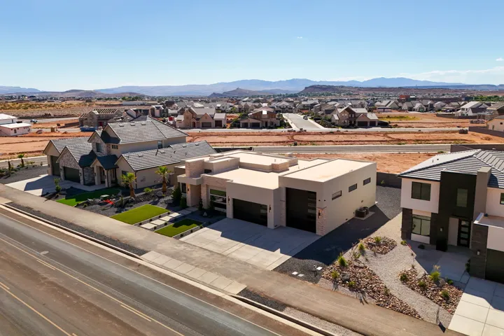Contemporary architecture featuring a flat roofline, integrated garage doors, and a desert-inspired landscaping with gravel and native plantings