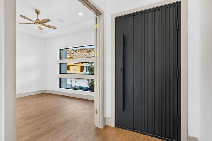 Modern entry door with vertical paneling and a dark finish