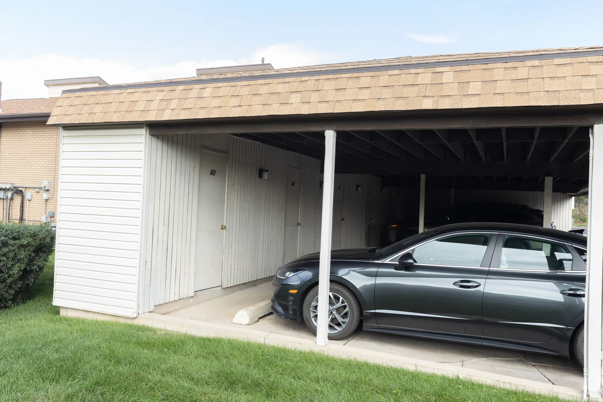 Covered parking structure with asphalt shingle roofing