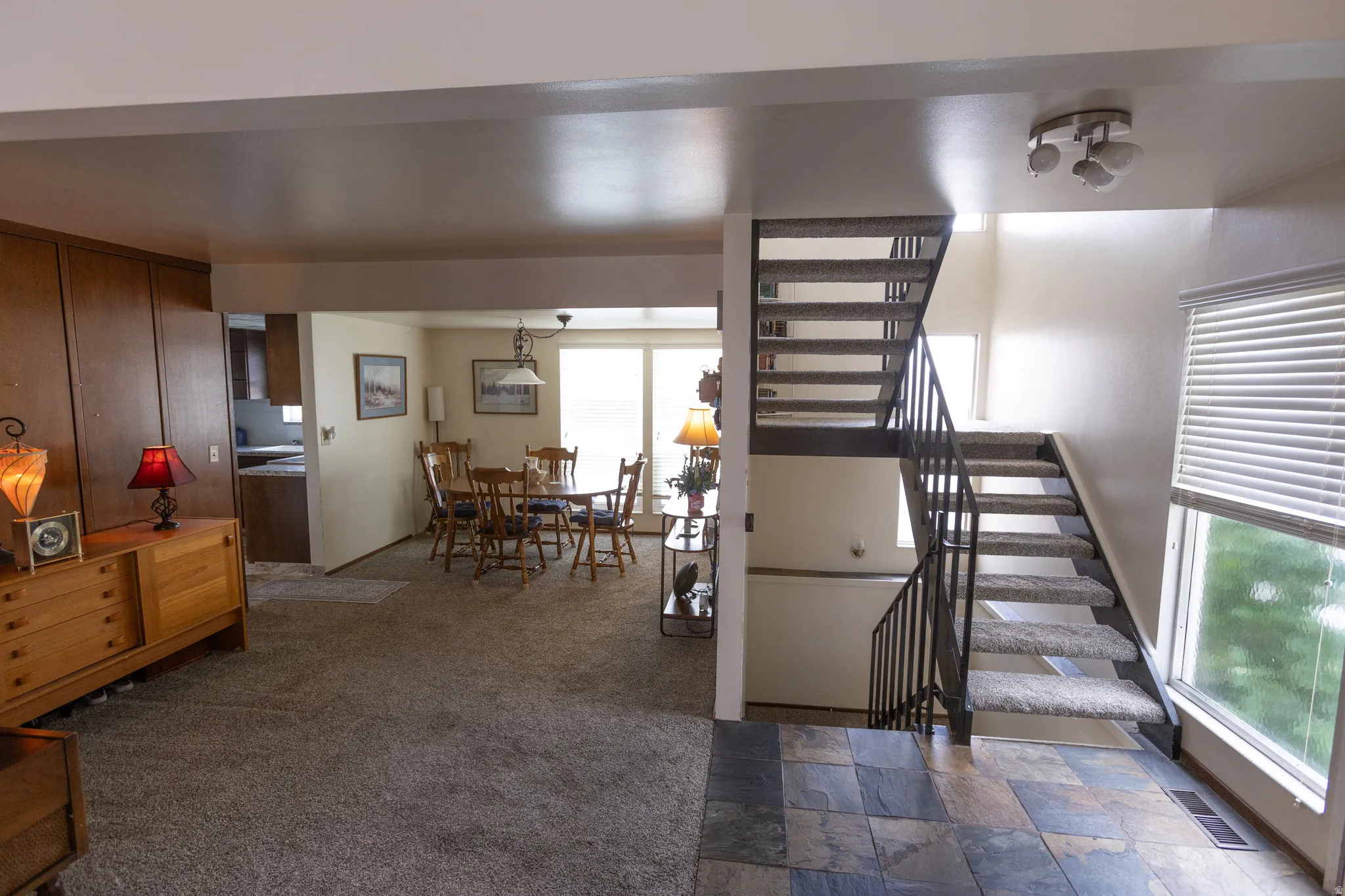 Multi-level interior featuring a carpeted staircase with metal railings