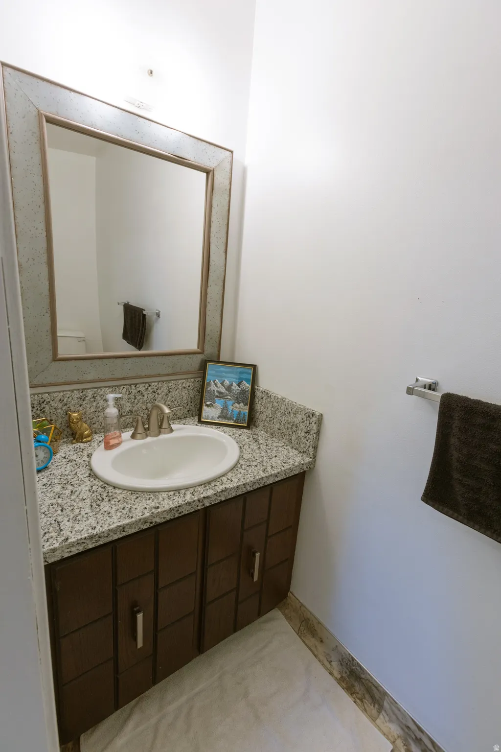 Vanity with a granite countertop and an undermount sink