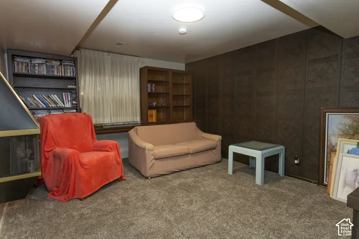 Carpeted room with a built-in fireplace, two built-in shelving units, and paneled walls