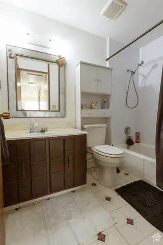 Bathroom featuring a vanity with dark wood-finish cabinetry, a framed mirror, and a built-in storage unit