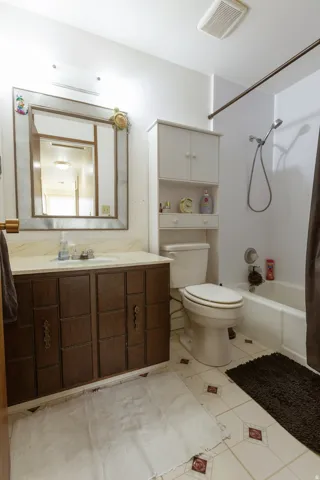 Bathroom featuring a vanity with dark wood-finish cabinetry, a framed mirror, and a built-in storage unit