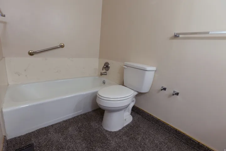 White bathtub with a chrome grab bar