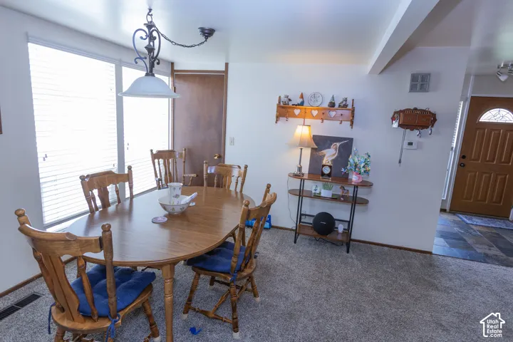 Carpet flooring, multiple windows with blinds, wood-finish interior doors, and a decorative ceiling light fixture