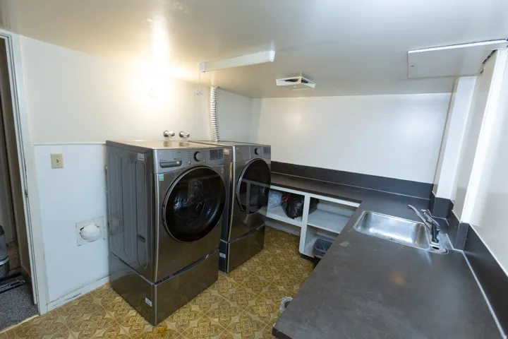 Utility room featuring a built-in countertop, integrated sink, and open shelving