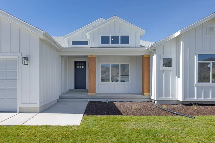 White board and batten exterior with wood-clad columns and an attached garage