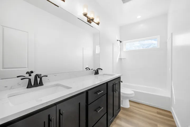 Dual vanity with white countertop and dark cabinetry