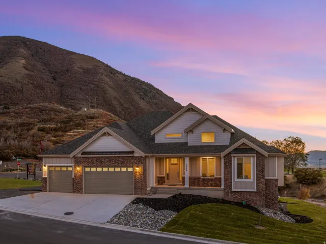 Contemporary residence featuring a multi-tone exterior, attached three-car garage, and a concrete driveway